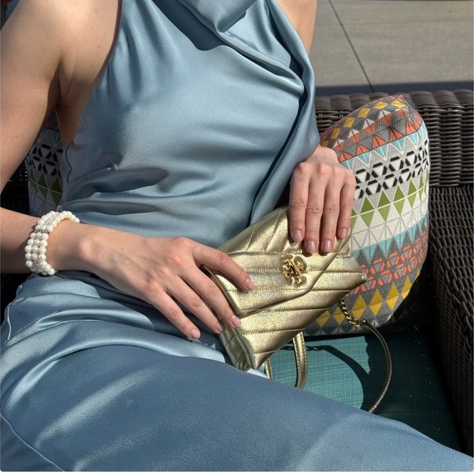 Gold quilted handbag against a blue satin dress