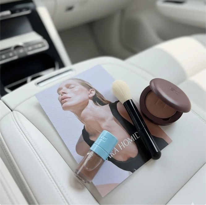 Beauty products and a magazine on a white car seat