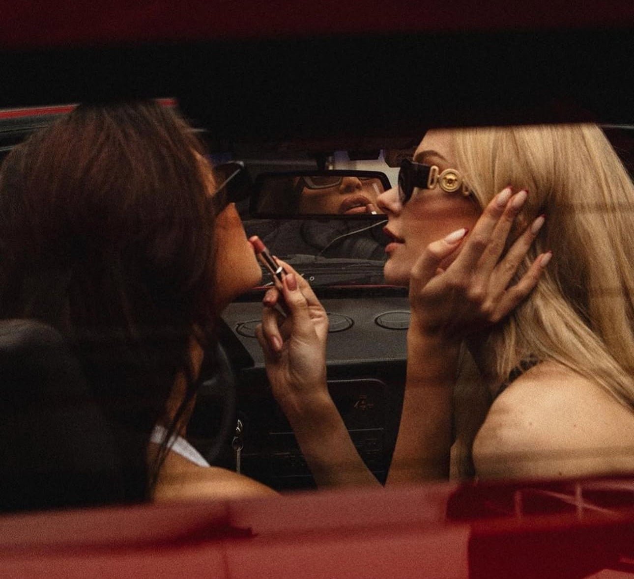 Applying lipstick in a car mirror