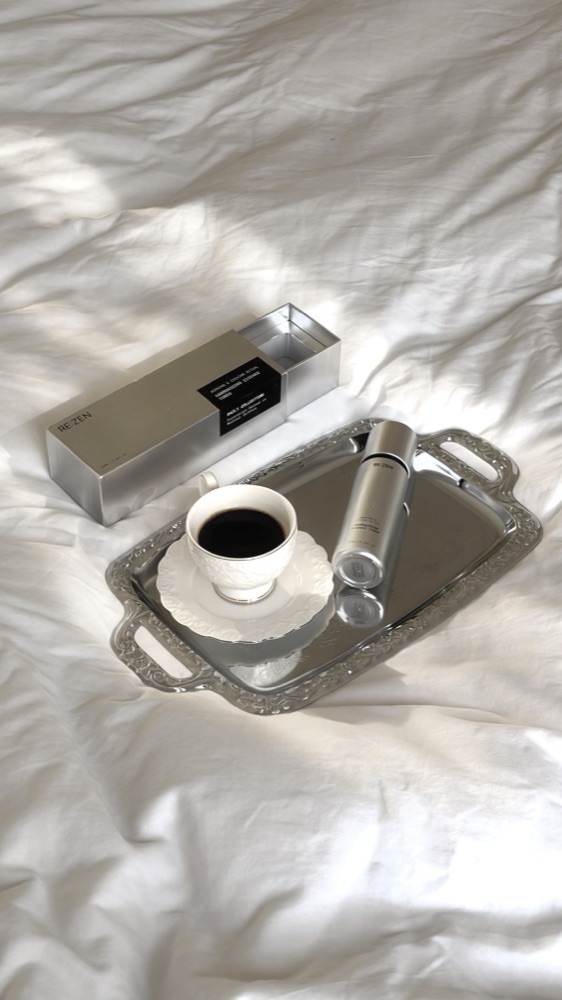 RE:ZEN essence toner on a silver tray with an espresso cup